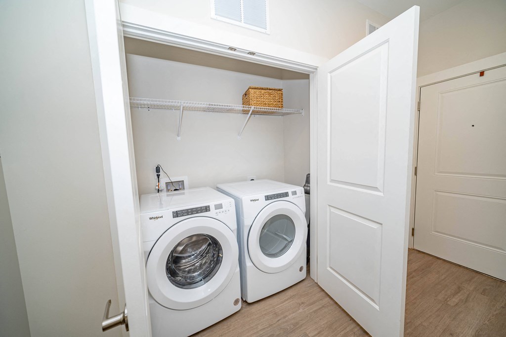 a white washer and dryer in a laundry room with a white door