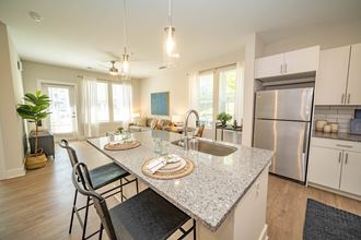 an open kitchen and dining area with a granite counter top