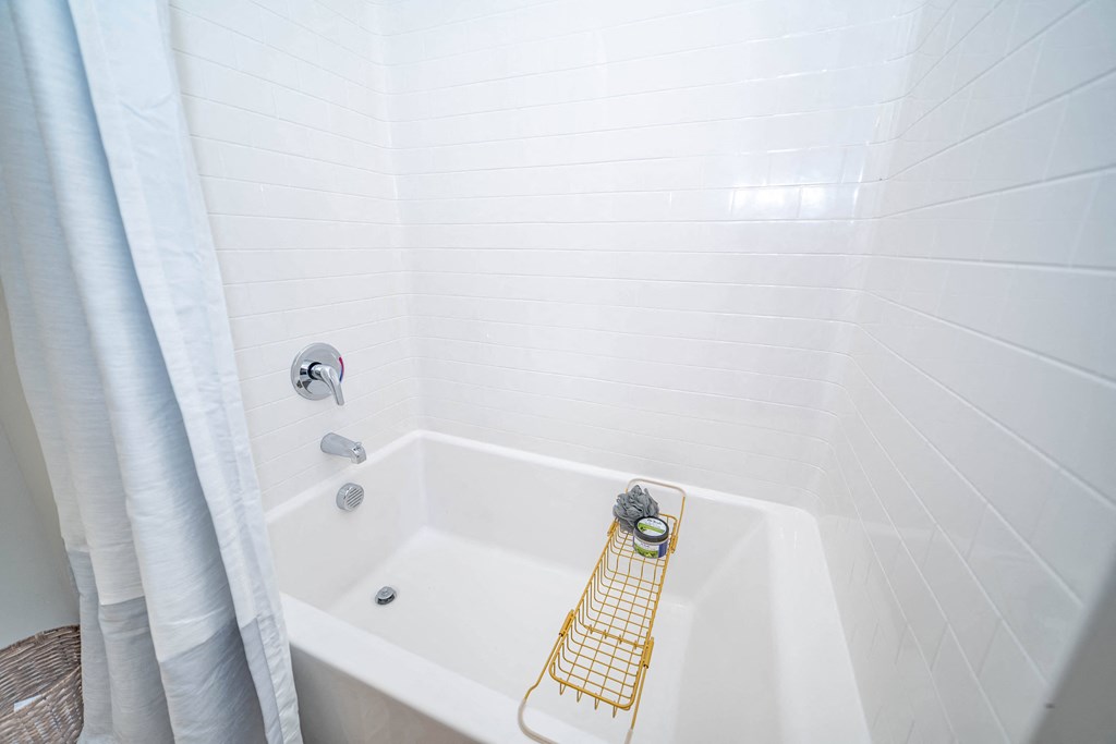 a bathroom with a white tub and a shower curtain