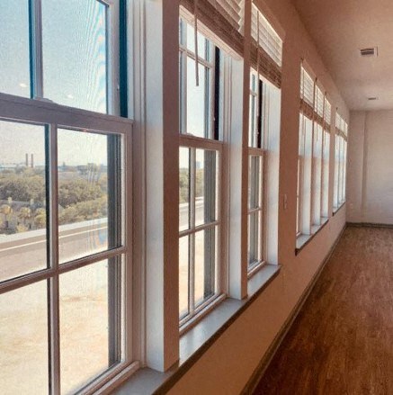 a living room with large windows and a wooden floor