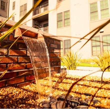 a water fountain in a yard in front of a building