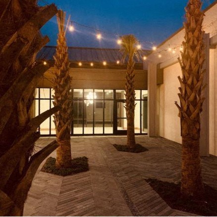 a courtyard with palm trees in front of a building