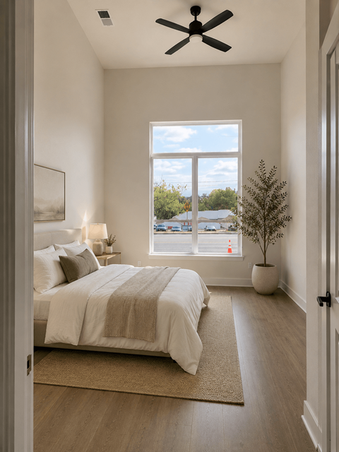 A bedroom with a large bed and a window overlooking a parking lot.