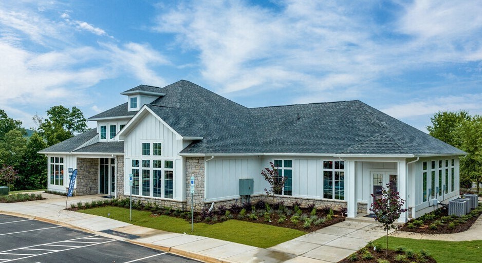 the front of a house with a lawn and a driveway