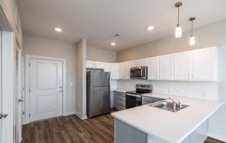 A kitchen with white cabinets and a white island.