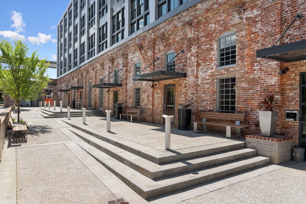 the sidewalk outside of a brick building with concrete steps