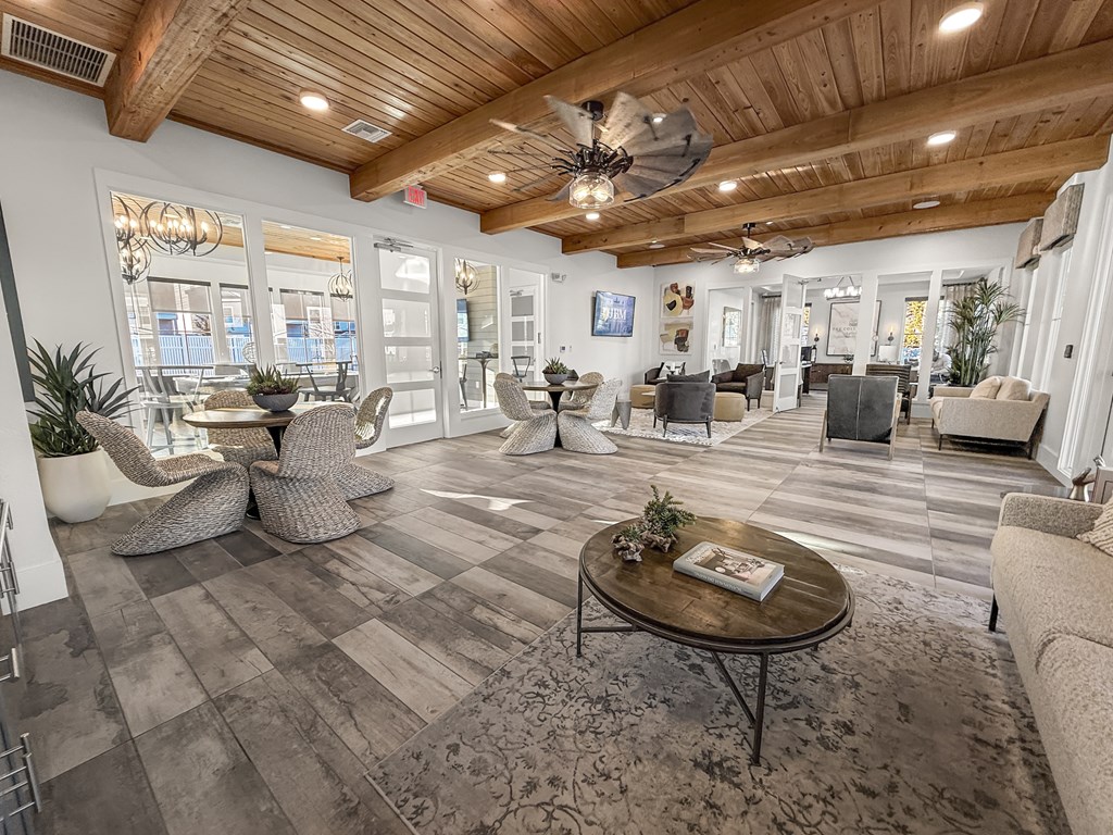 A living room with a wooden ceiling and a large window.