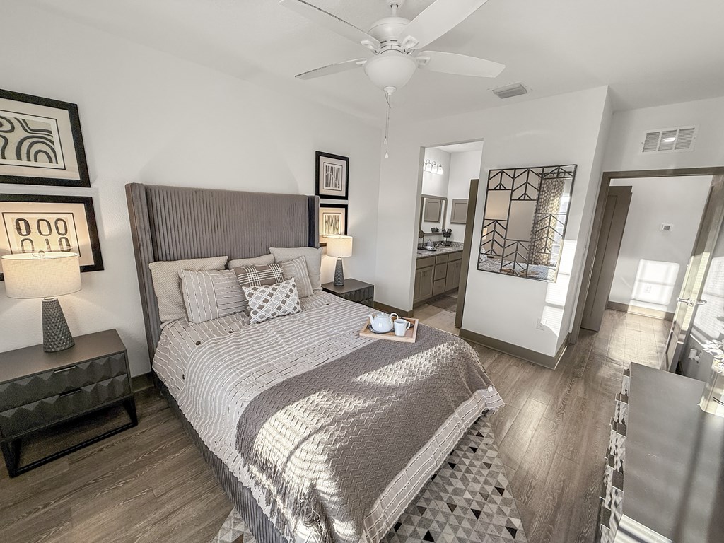 A bedroom with a large bed and a ceiling fan.