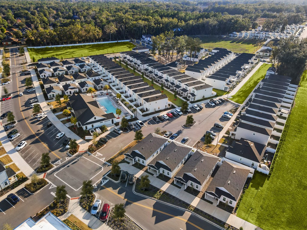 A bird's eye view of a residential area with houses and a swimming pool.