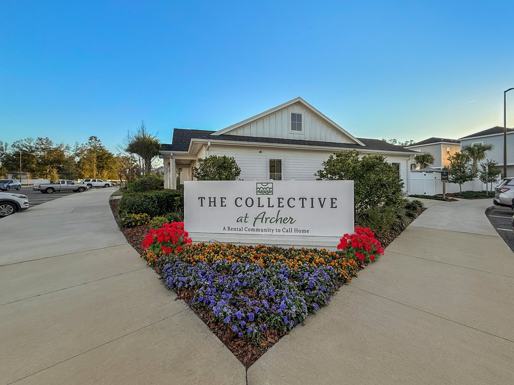 A sign that says "The Collective at Archer" in front of a house.