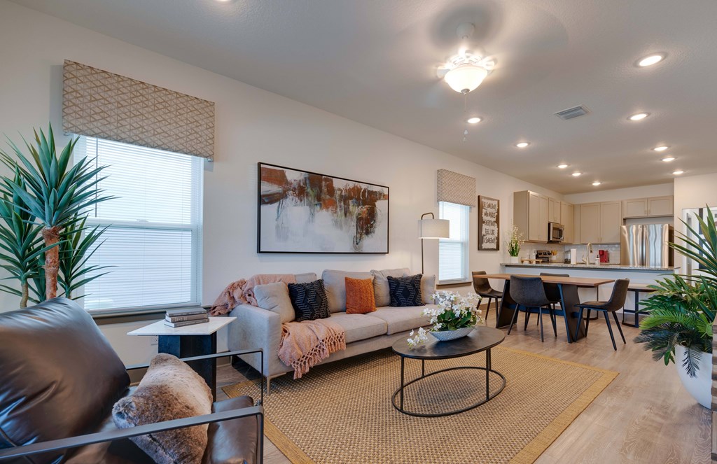 A living room with a couch, chairs, and a dining table.