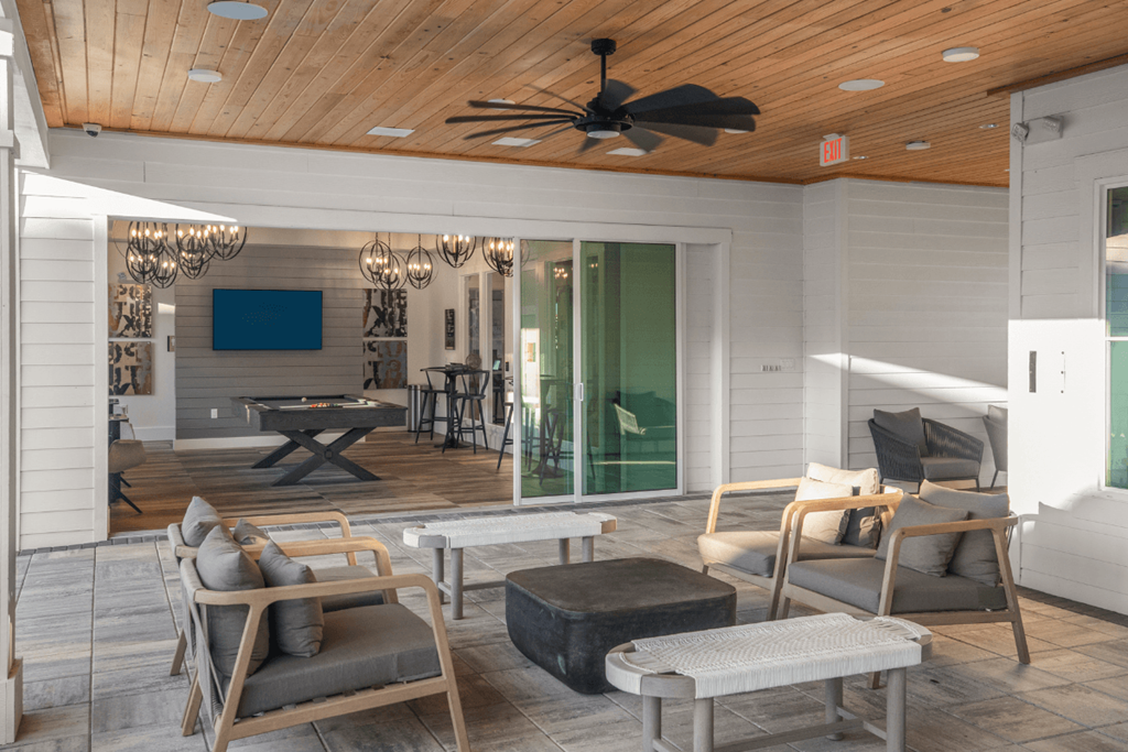 A modern outdoor patio with a wooden ceiling fan.