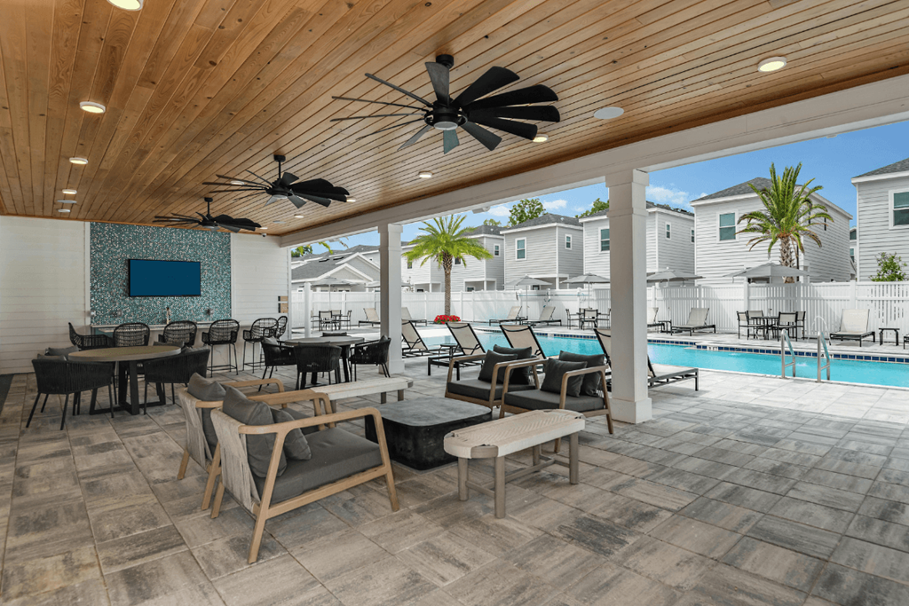 A modern outdoor living space with a pool and a ceiling fan.