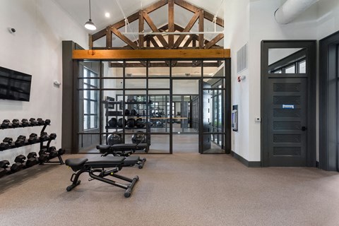 a gym with weights and a glass door
