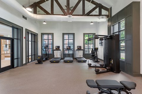 a gym with weights and other equipment in a room with windows