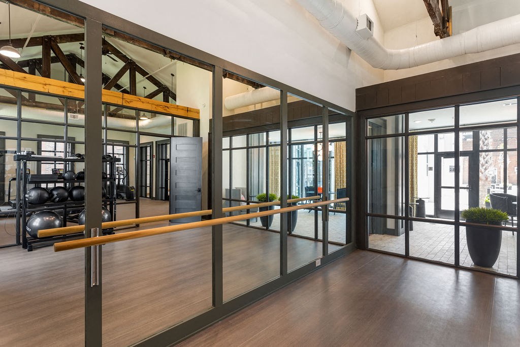 a workout room with glass walls and a wood floor