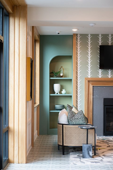 a living room with a wicker chair and a fireplace