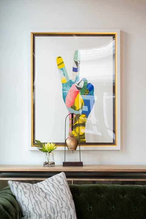 a painting of a hand on a wall next to a couch