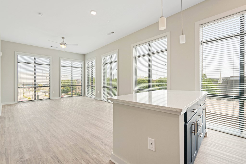 an open kitchen and living room with a large island and windows