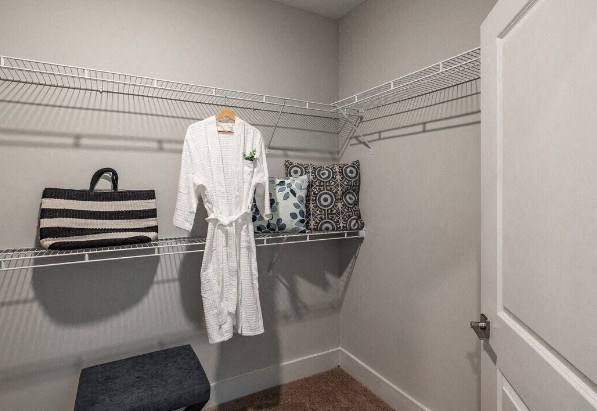 a white robe hanging on a rack in a closet