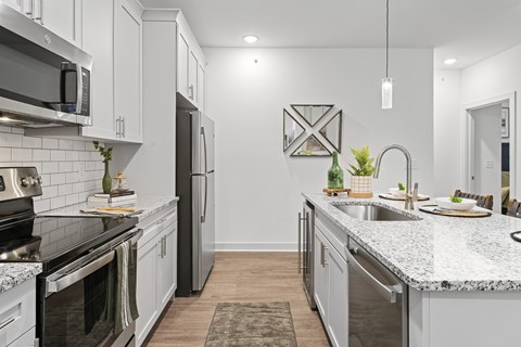A modern kitchen with a black stove top oven and a granite counter top.