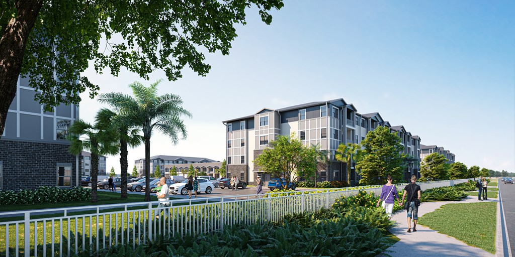 A modern apartment complex with a white picket fence and greenery in the foreground.
