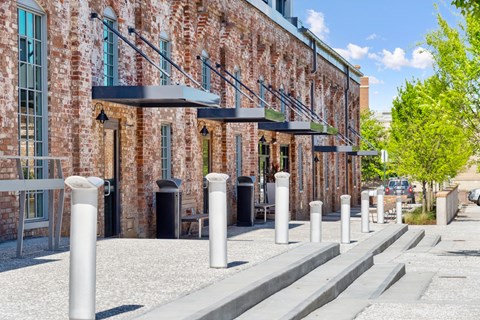 the facade of a brick building with a sidewalk and pillars