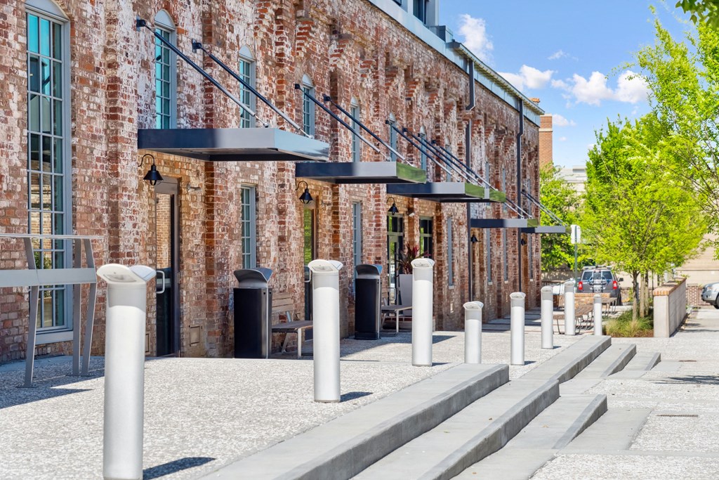 the facade of a brick building with a sidewalk and pillars