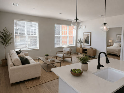 A modern living room with a white kitchen island and a beige sofa.
