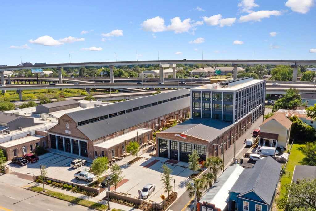 an aerial view of a building with a highway in the background