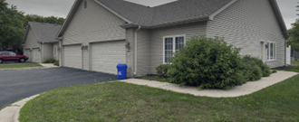 a house with a blue trash can in front of it