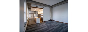 a living room with a kitchen and a wood floor