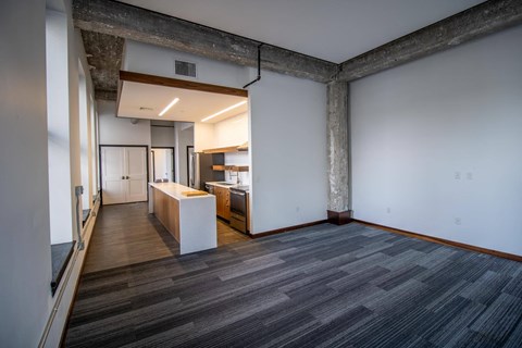 a living room with a kitchen and a wood floor