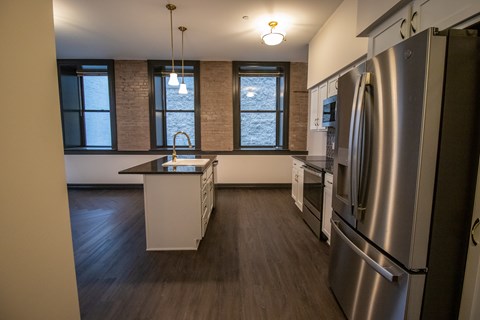 A modern kitchen with a large island and stainless steel appliances.
