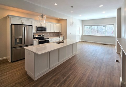 A modern kitchen with a refrigerator, oven, and microwave.