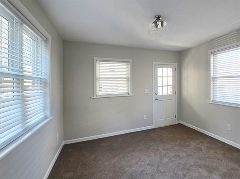 A room with a carpeted floor and a door.