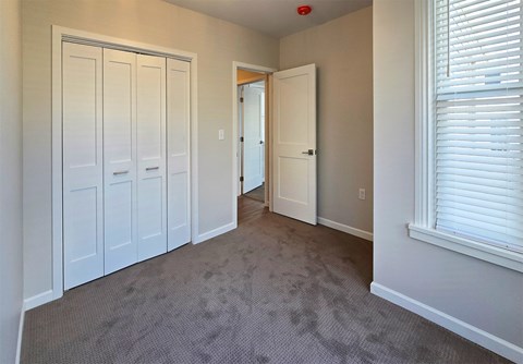 A room with white doors and a carpeted floor.