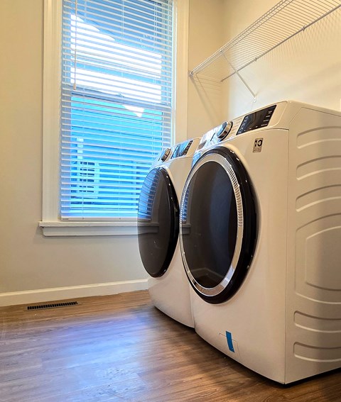 Two front load washing machines in a laundry room.