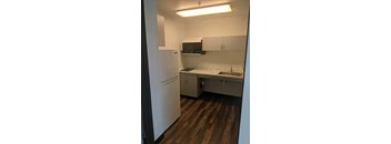 a kitchen with white cabinets and a sink and a refrigerator