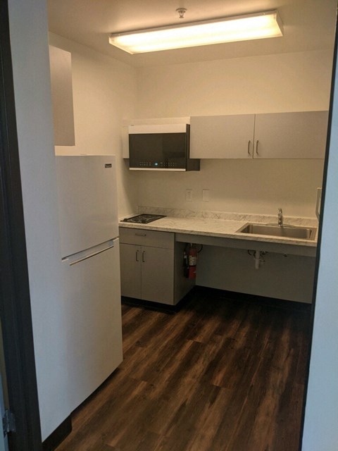 a kitchen with white cabinets and a sink and a refrigerator