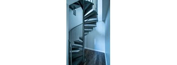 a spiral staircase in a house with a white wall