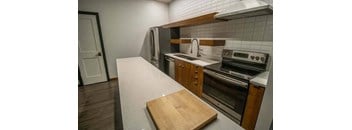 a kitchen with a counter and a stove and a refrigerator