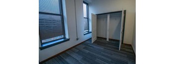an empty room with a window and a closet