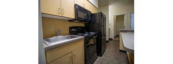a kitchen with a sink and a black refrigerator