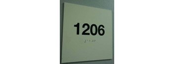 a white sign with numbers on a white wall