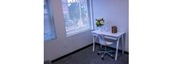 a desk with a chair in a room with a window