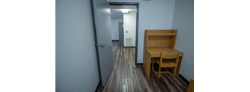 a wooden table and chair in a room with a door