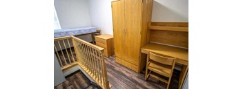 a room with a desk and a chair and a staircase