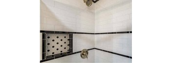 a white tiled bathroom with a shower and a sink