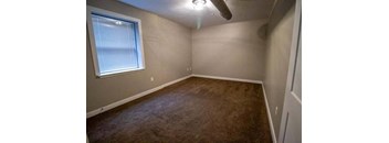 an empty room with a window and a ceiling fan